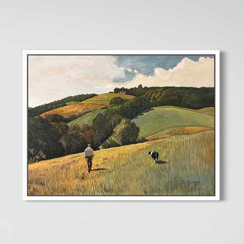 Framed artwork of a landscape with a person and dog walking on a hillside.